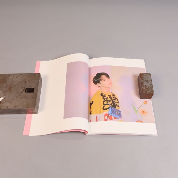Uppslagen fotobok med idolbild ur BTS-album