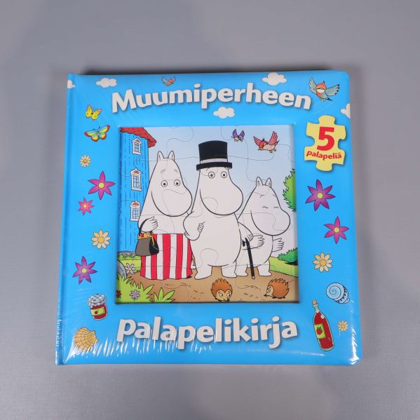 Framsidan av Muumiperheen pusselbok i blått med Muminfamiljen