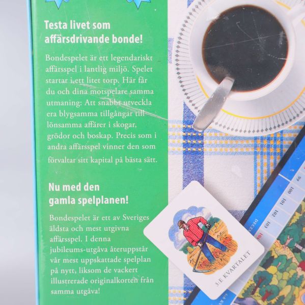 Närbild på text om Bondespelet och spelkortsmotiv
