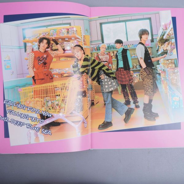 Uppslagen fotobok med färgstarkt foto av bandmedlemmar i butik