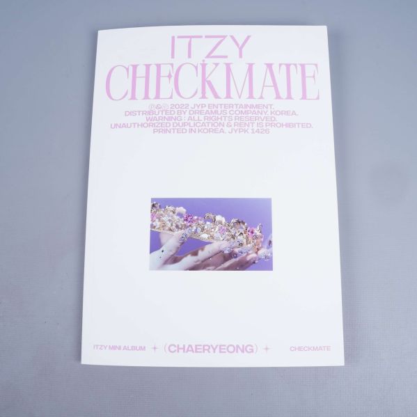 Baksidan av ITZY CHECKMATE album med dekorativ hand-bild