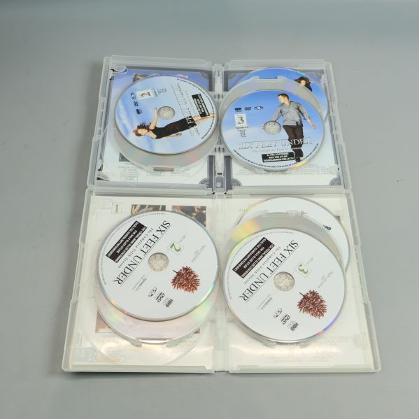 Öppna DVD-fodral visar flera Six Feet Under-skivor