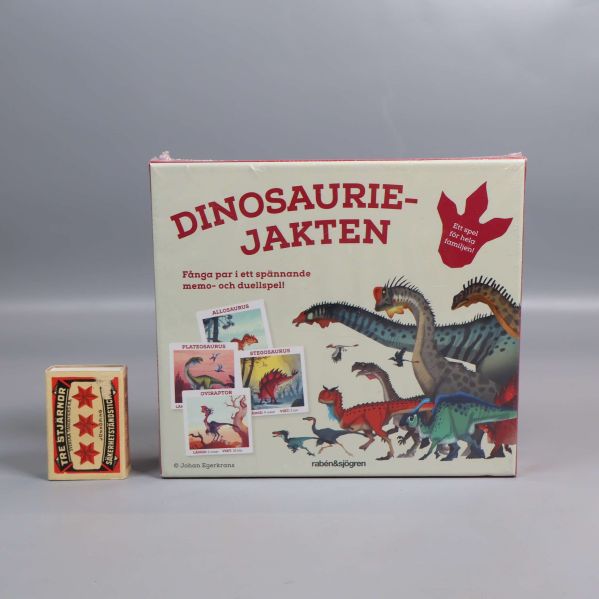 Spelboxen Dinosauriejakten bredvid en tändsticksask för storleksjämförelse