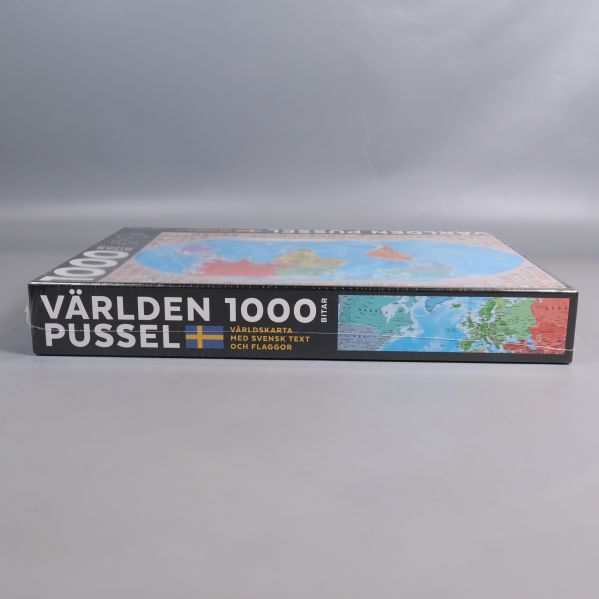 Sidovy av pusselask med kartmotiv samt text och flaggor