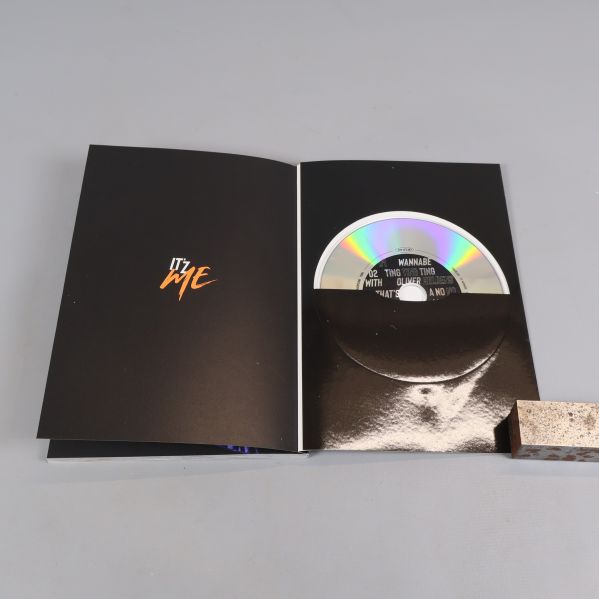 Album öppnat med CD-skiva i ficka och orange text