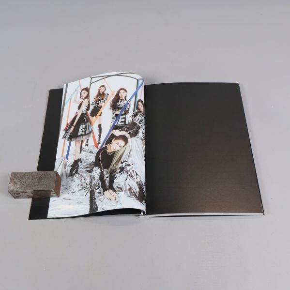 Fotobok öppen mot en sida med gruppfotografi i helfigur