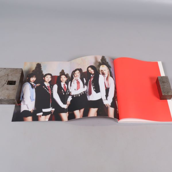 Uppslagen fotobok med färgbild på K-pop grupp
