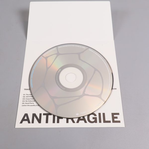 CD-skiva i vit albumfolder med svart text