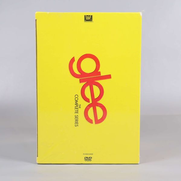 Gul framsida på Glee DVD-box med röd text