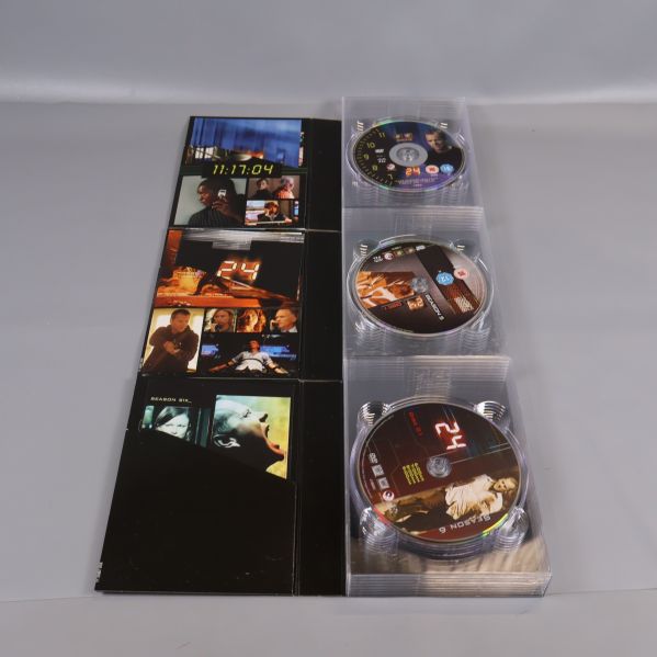 Tre öppnade DVD-fodral till 24 med tydliga serienumreringar på skivorna