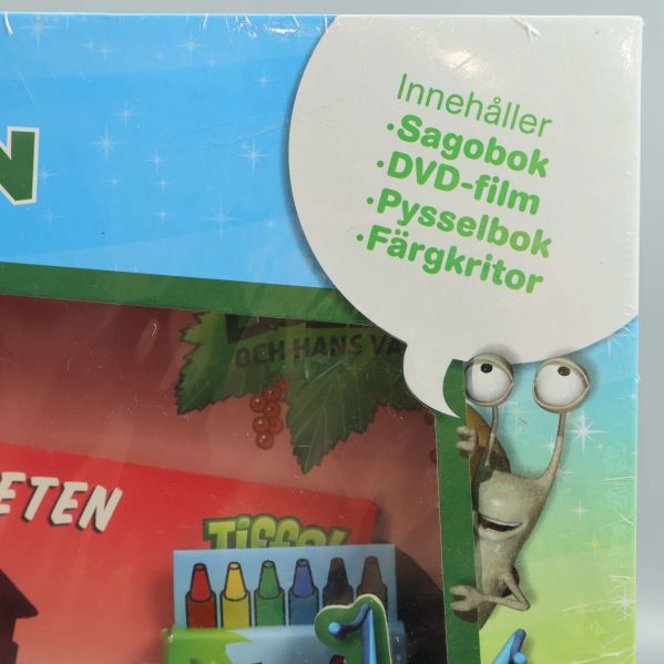 Närbild på text om innehåll: sagobok, DVD-film, pysselbok, färgkritor