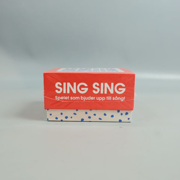 Sida av lådan med texten Sing Sing spelet som bjuder upp till sång