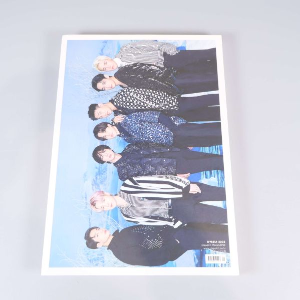 Baksidan av boken med BTS gruppfoto mot blå bakgrund