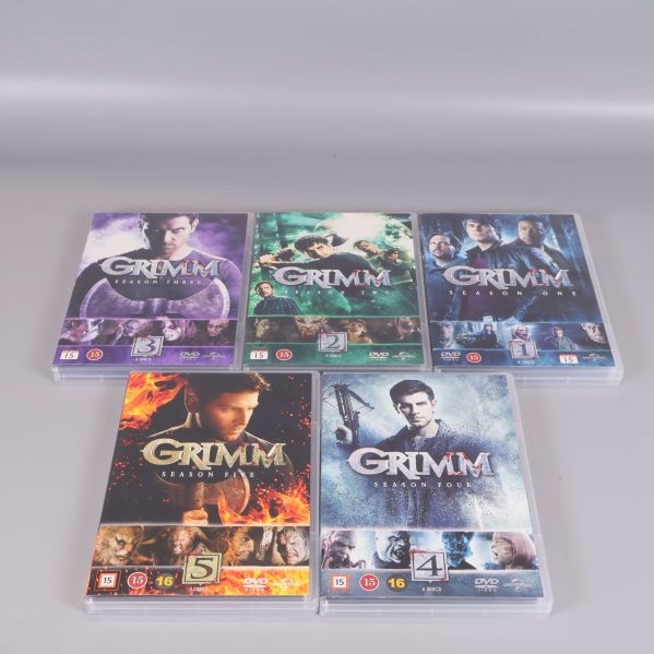 Fem Grimm dvd-fodral utlagda och omslagen synliga
