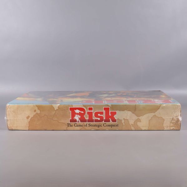 Risk spelkartongens långsida visar logotyp och åldersrekommendation