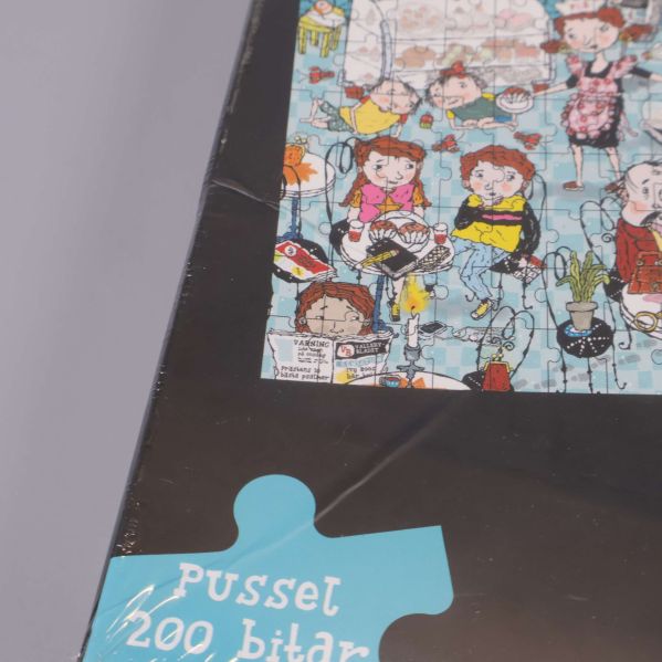 Närbild på askens hörn och texten pussel 200 bitar