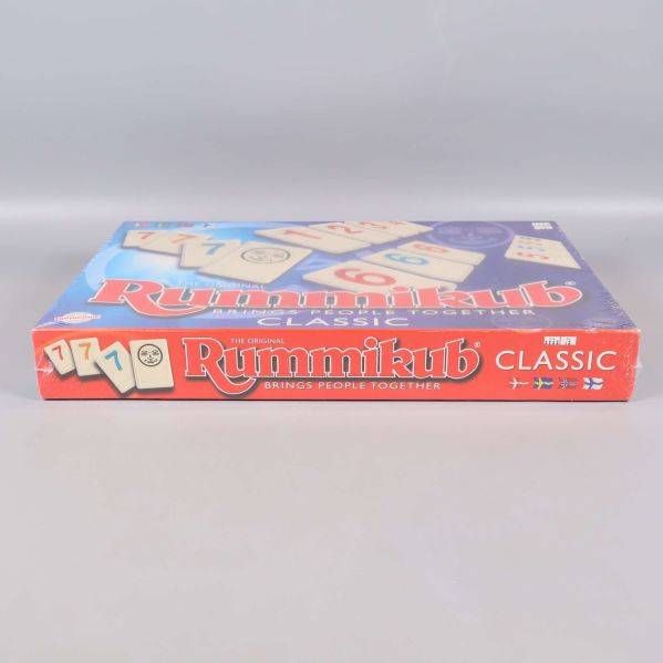 Övre sidan av Rummikub-låda med logotyp och brickor