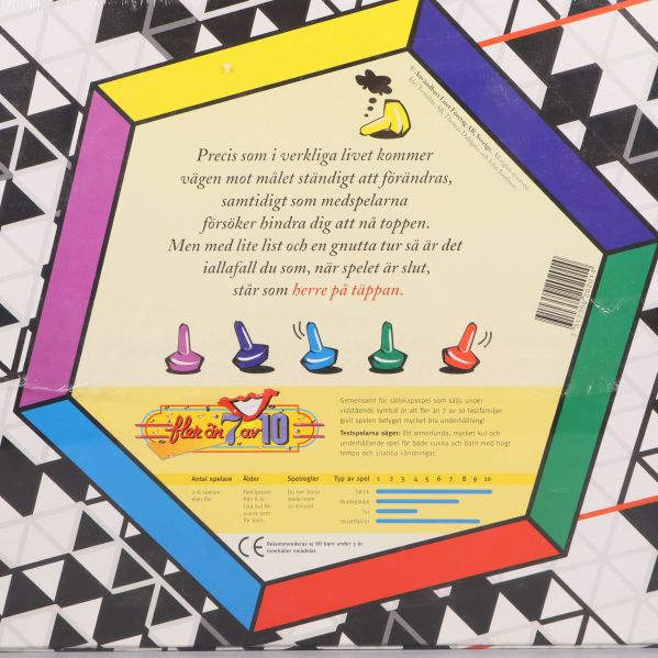 Närbild av spelkartongens baksida med regler och färgglada pjäser
