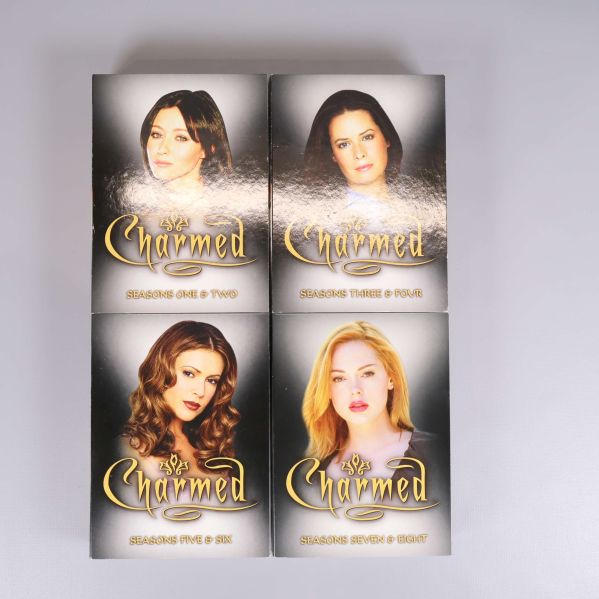 Fyra framsidor av dvd-fodral för Charmed med säsongsbeskrivningar