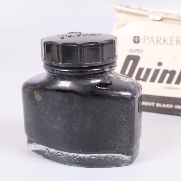 Svart bläckflaska nära originalförpackning från Parker Quink