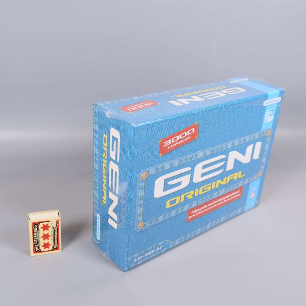 Geni Original spelask bredvid tändsticksask för storleksreferens