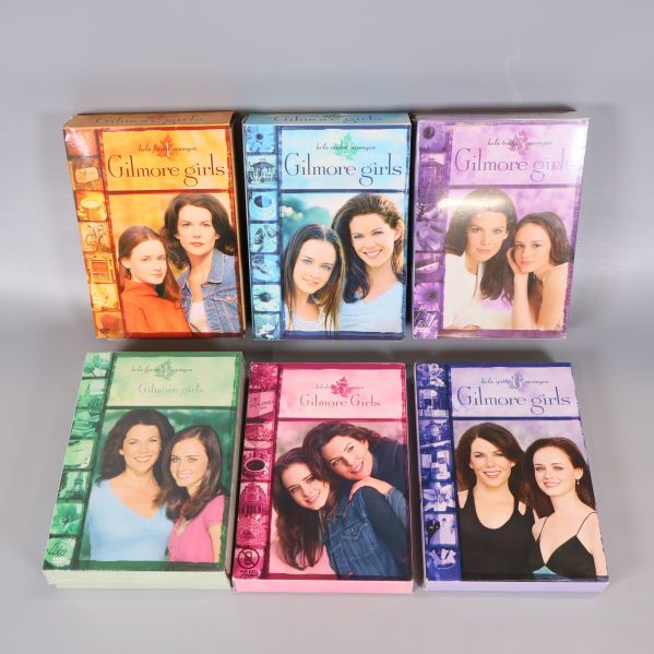 Sex separata Gilmore Girls boxar upplagda på bord