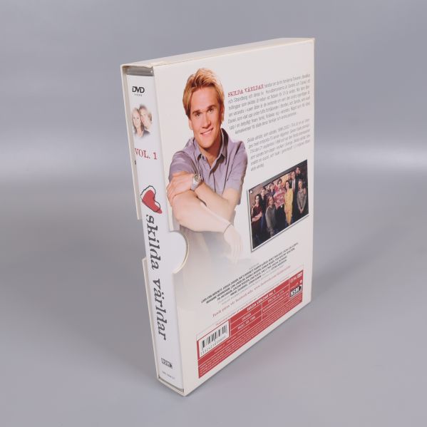 Dvd-boxen Skilda världar volym 1 lutar mot bakgrunden med baksidan synlig