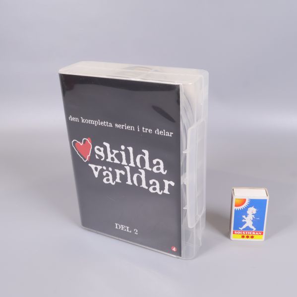 Dvd-box Skilda världar del 2 bredvid tändsticksask för storleksjämförelse