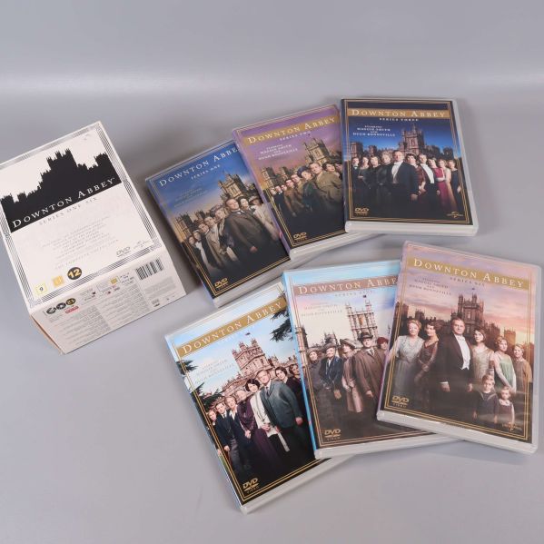 Downton Abbey DVD-box och sex fodral placerade bredvid varandra