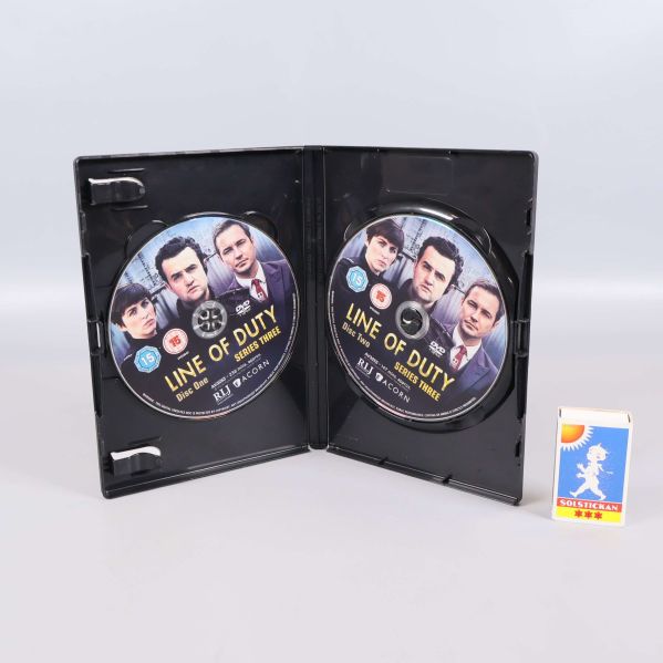 Öppen DVD-box med två Line of Duty-skivor och tändsticksask bredvid