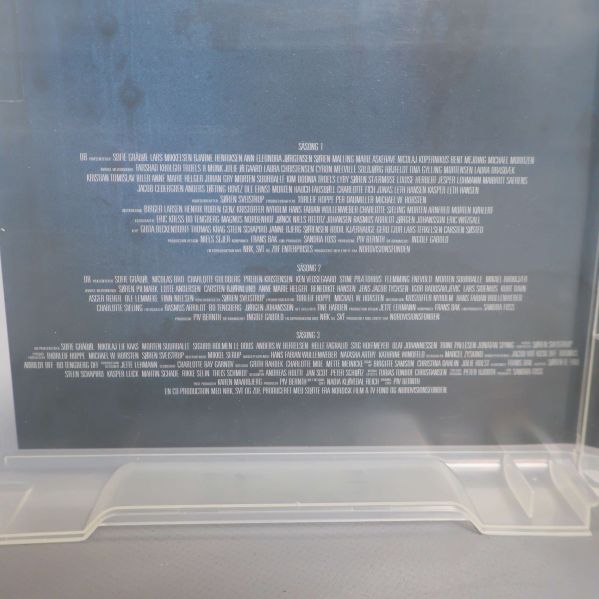 Närbild av liten vit text med produktionsdetaljer inuti DVD-boxen