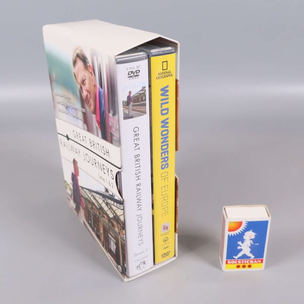 DVD-box med två fodral stående bredvid en tändsticksask för storleksjämförelse
