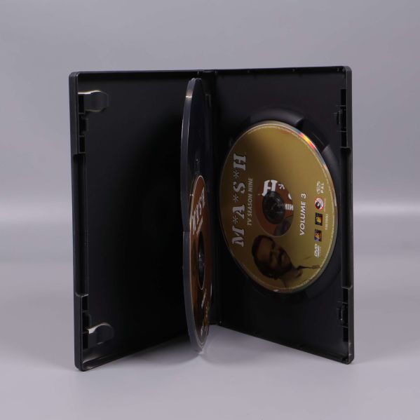 Öppen DVD-box med tre MASH-skivor synliga inuti
