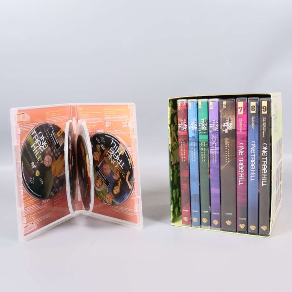 Öppet DVD-fodral med två skivor och box med säsongsfodral bredvid