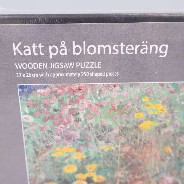 Närbild på pusselaskens hörn med text om pusslets motiv och bitantal