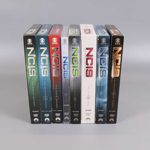 Spinnsidor av sju NCIS DVD-säsongsboxar i olika färger