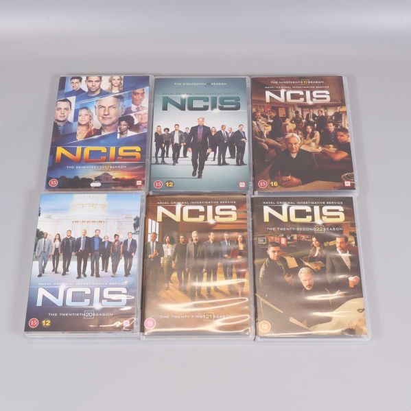 Sex säsonger av NCIS i sina DVD-fodral framifrån