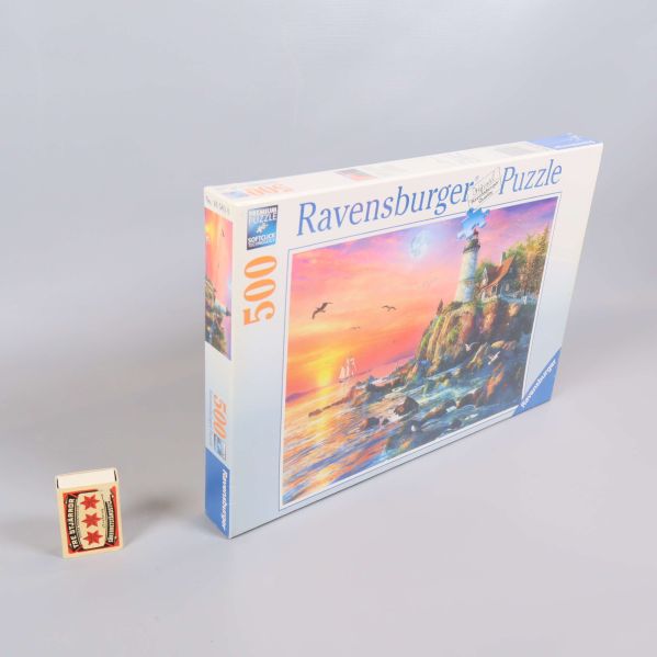 Ravensburger pussel bredvid tändsticksask för storleksjämförelse