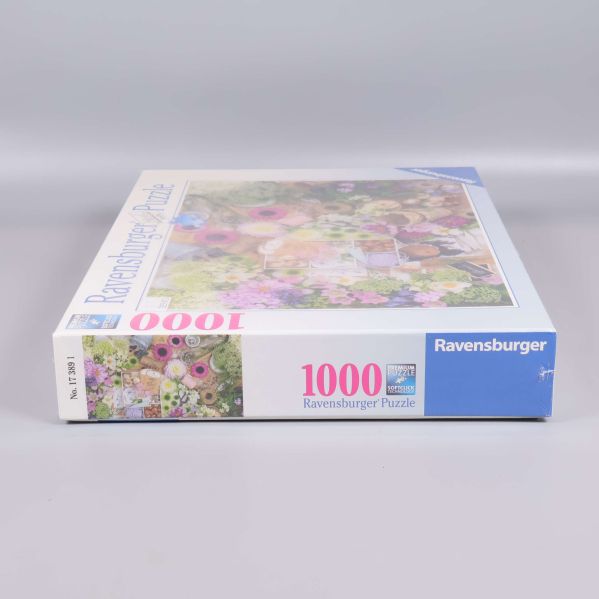 Pusselask liggande med 1000 bitar text och Ravensburger-logga