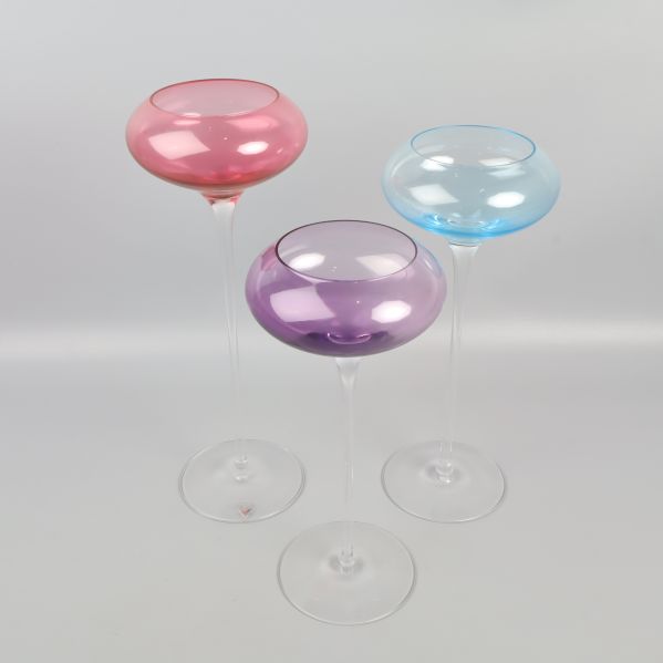 Tre färgade cocktailglas i olika färger