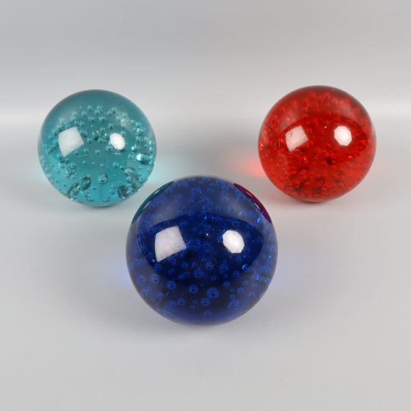 Tre glaskulor med bubblor i olika färger