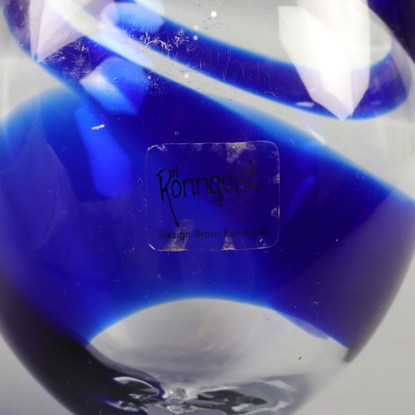 Märkning på glasprydnad med text "Rönnquist Design"