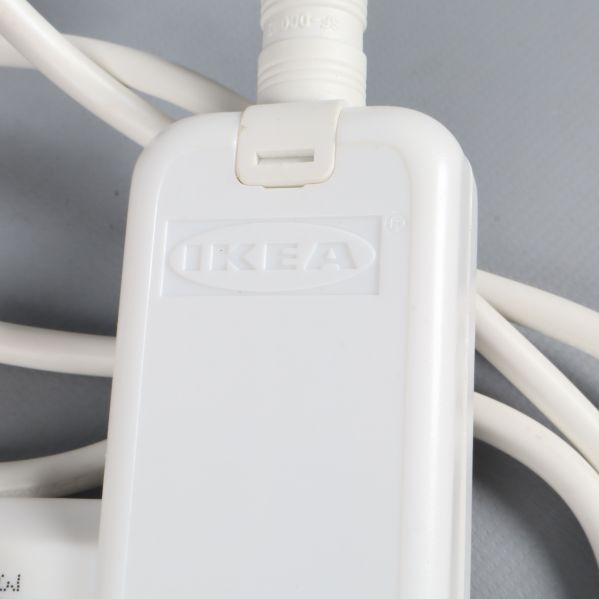 Närbild på vit IKEA adapter med logotyp