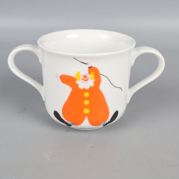 Mugg med orange figurmotiv och handtag