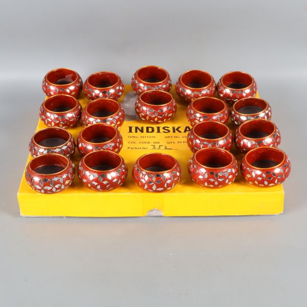 Röda ljushållare på en gul kartong