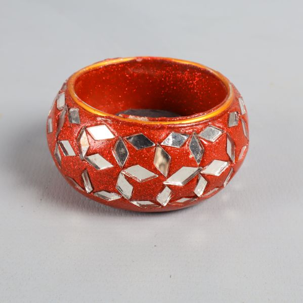 En röd ljushållare med mönster