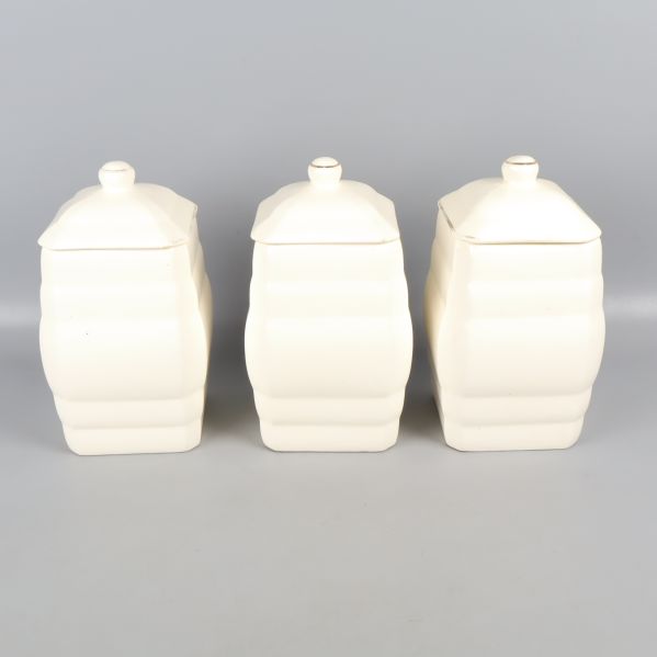 Baksida av tre vita burkar