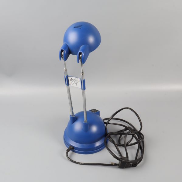 Bakre vy av blå skrivbordslampa och elkabel