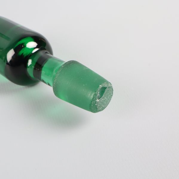 Närbild på grön glas knopp kantstött