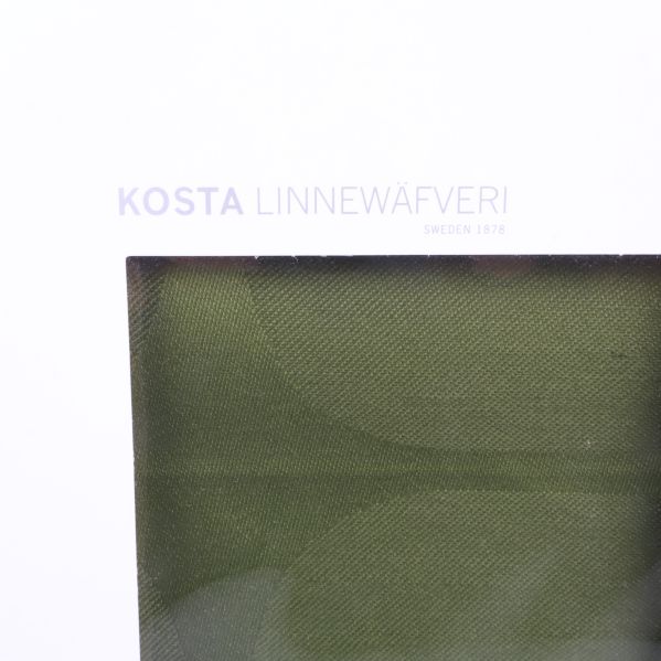 Närbild på Kosta Linnewäfveri-loggan på vit kartong